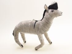 a stuffed donkey with a black hat on it's head is standing in front of a white background