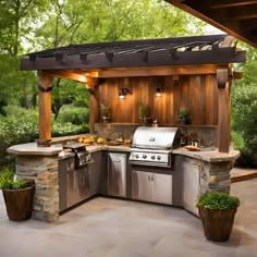 an outdoor kitchen with grill, sink and potted plants