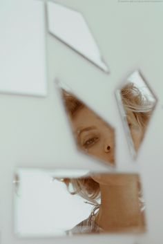 the reflection of a woman's face in a mirror with other images on it