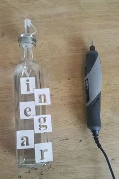 a glass bottle sitting on top of a wooden table next to a power cord and plugged in