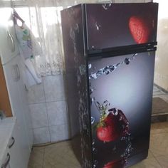 two refrigerators with pictures of strawberries on them in a kitchen next to a sink