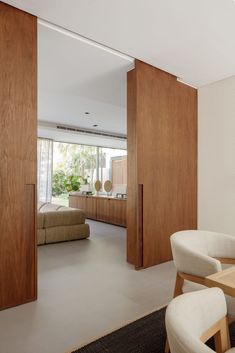 a living room filled with furniture next to a kitchen and dining room table in front of a sliding glass door