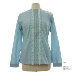 a mannequin wearing a light blue shirt with lace trimmings on it