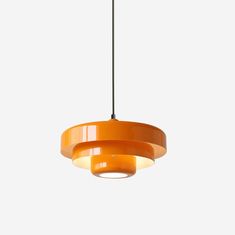 an orange pendant light hanging from a ceiling