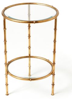 a round glass table with gold trimmings on the top and bottom, against a white background