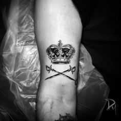 a man's foot with a crown and two swords on the left side of his leg