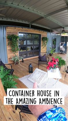 a man is pointing at something in the distance on his deck with chairs and potted plants