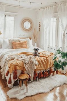 a bedroom with white walls, wooden floors and an orange blanket on top of the bed