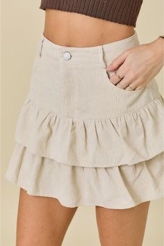 Introducing our Gemma Corduroy Ruffled Mini Skirt in ivory! Featuring belt loops, a button closure, and a ruffled hem, this skirt is perfect for those who love a touch of whimsy in their wardrobe. Paired with shorts, it's the ultimate combination of comfort and style. (Shorts included, exclamation optional.) Belt Loops Button Ruffled Hem Chic Cream Ruffled Skirt, Beige Ruffled Skirt Bottoms, Chic Beige Ruffled Skirt Bottoms, Chic Cream Tiered Skirt, Beige Ruffle Skirt For Fall, Fall Ruffled Beige Skirt, Chic Beige Ruffled Skirt, Chic Beige Skirt With Ruffle Hem, Fitted Beige Bottoms With Ruffle Hem