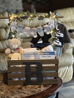 a wooden crate filled with baby's items on top of a table next to a couch