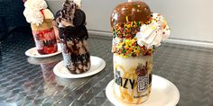 three ice cream sundaes with sprinkles and toppings on them