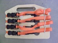 four pairs of scissors are on a cutting board with black handles and orange handles,