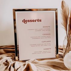 a dessert menu sitting on top of a table next to a vase with dried flowers