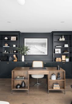 an office with black walls and wooden furniture