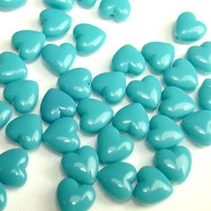 blue candy hearts are scattered on a white surface