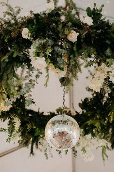 a chandelier with flowers and greenery hanging from it