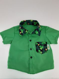 Classic button front collar shirt.  Features bold solid green fabric with contrasting collar and pocket of green and gold shamrocks on black, black buttons and short sleeves. A great shirt to dress up your little man for St. Patrick's Day. St. Patricks Day, Solid Green, Contrast Collar, Saint Patrick, Clothing Sets, Collar Shirt, Black Button, Green Fabric, Clearance Sale