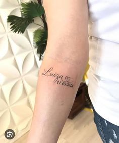 a woman with a tattoo on her arm that says, lupa is born in cursive writing