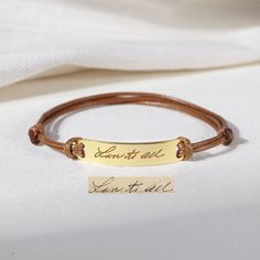 a close up of a bracelet with a name tag on the clasp and a handwritten message