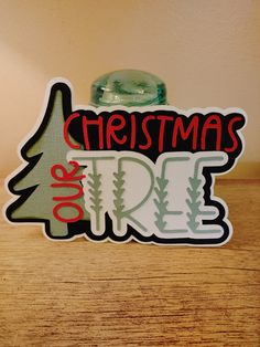 a christmas ornament on top of a wooden table next to a green bottle