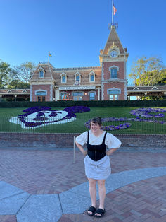 a woman standing in front of a large building