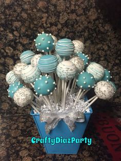 blue and white cake pops are arranged in a vase