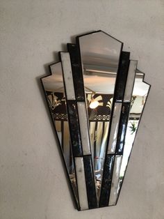 a mirror mounted to the side of a wall next to a light fixture on a wall