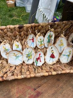 some ornaments are sitting in a basket on a wooden table with grass and other items