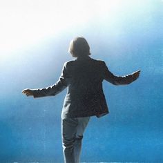 a man standing on top of a snow covered ground holding his arms out to the side