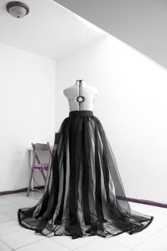 a black and white photo of a dress on display in a room with tile flooring