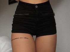 a woman wearing black shorts with writing on the side and zippers at the waist