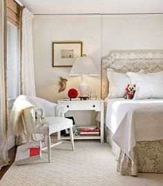 a bedroom with a bed, two chairs and a table in front of the bed