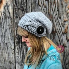 a woman wearing a gray knitted hat with black buttons