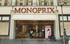 people walking in front of a store with the word monoprix on it's side