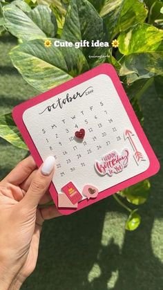 someone is holding up a calendar card with hearts on it and the date for october