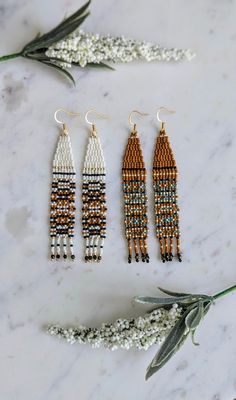 three beaded earrings on a marble surface