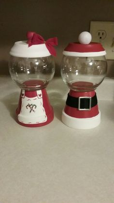 there are two snow globes sitting on the counter top, one is red and white