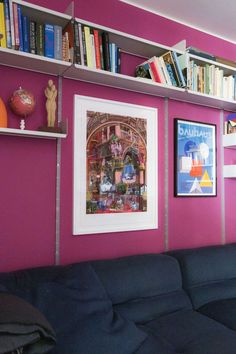 a living room with purple walls and bookshelves filled with various types of books