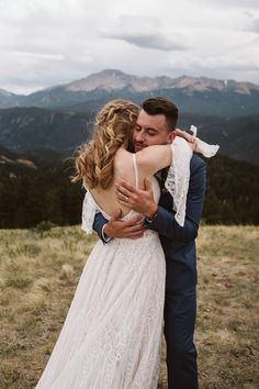 a bride and groom embracing in the mountains