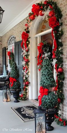 the front porch decorated for christmas with red and green decorations