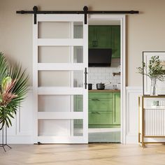 an open door leading to a kitchen with green cabinetry and white walls, along with a potted plant