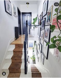 a staircase with pictures on the wall and wooden steps leading up to the second floor