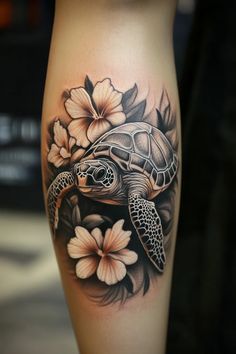 a woman's leg with a turtle and flowers on it