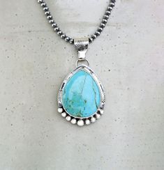 Kingman Sky Blue Turquoise Sterling Silver Necklace on your choice of chain. The setting is a chunky teardrop stone that is 27mm x 22mm and in a Bezel setting. The 925 Sterling Silver has been lightly oxidized.  Your choice of an 18" 3mm Navajo Pearls or 18" Silver Chain with Lobster clasp This cool necklace features a chunky, pear shaped turquoise gemstone with a detailed setting. The soothing hue of the turquoise brings out a southwest style vibe, while the silver accents add a touch of elegan Bohemian Teardrop Jewelry With Large Stone, Bohemian Teardrop Large Stone Jewelry, Southwestern Style Teardrop Gemstone Jewelry, Southwestern Teardrop Gemstone Jewelry, Bohemian Teardrop Large Stone Necklace, Artisan Turquoise Teardrop Pendant Necklace, Handmade Southwestern Necklace With Teardrop Pendant, Blue Turquoise Necklace With Large Teardrop Stone, Handmade Southwestern Teardrop Pendant Necklace