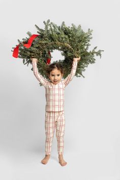 a little boy holding a christmas tree on his head