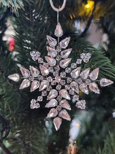 a snowflake ornament hanging from a christmas tree