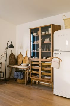 a white refrigerator freezer sitting in a kitchen next to a wooden table and chairs