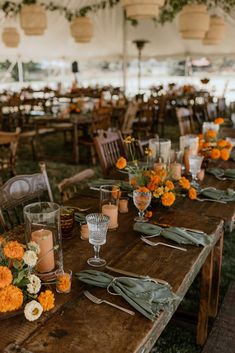 the tables are set with candles, flowers and napkins for an outdoor wedding reception