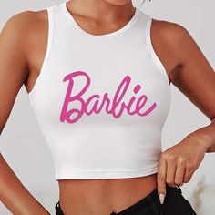 White Barbie Crop Top Size L (8-10). The Material Is A Nice Stretchy Fabric. White Stretch Tank Top With Letter Print, White Sleeveless Top With Logo Print, Cute Stretch White Crop Top, White Sleeveless Letter Print Crop Top, Trendy White Crew Neck Tank Top, White Logo Print Crop Top For Summer, White Logo Print Crop Top For Spring, Trendy White Tank Top With Letter Print, Trendy White Crop Top With Logo Print