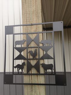 a metal sign with animals on it in front of a building